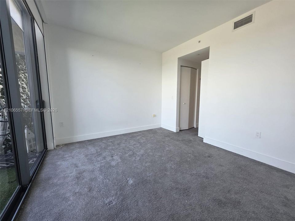Interior space featuring floor-to-ceiling glass sliding doors, wall-to-wall carpeting, and a built-in closet with folding doors
