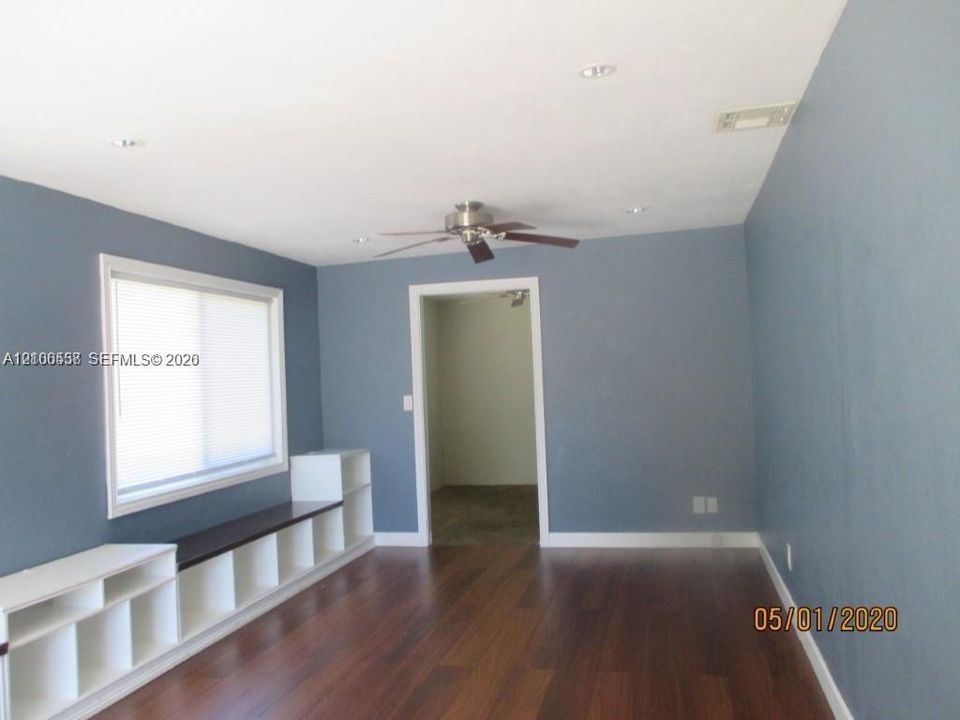 Room featuring wood-finish flooring, built-in white shelving with a dark-tone top, a ceiling fan, and recessed lighting