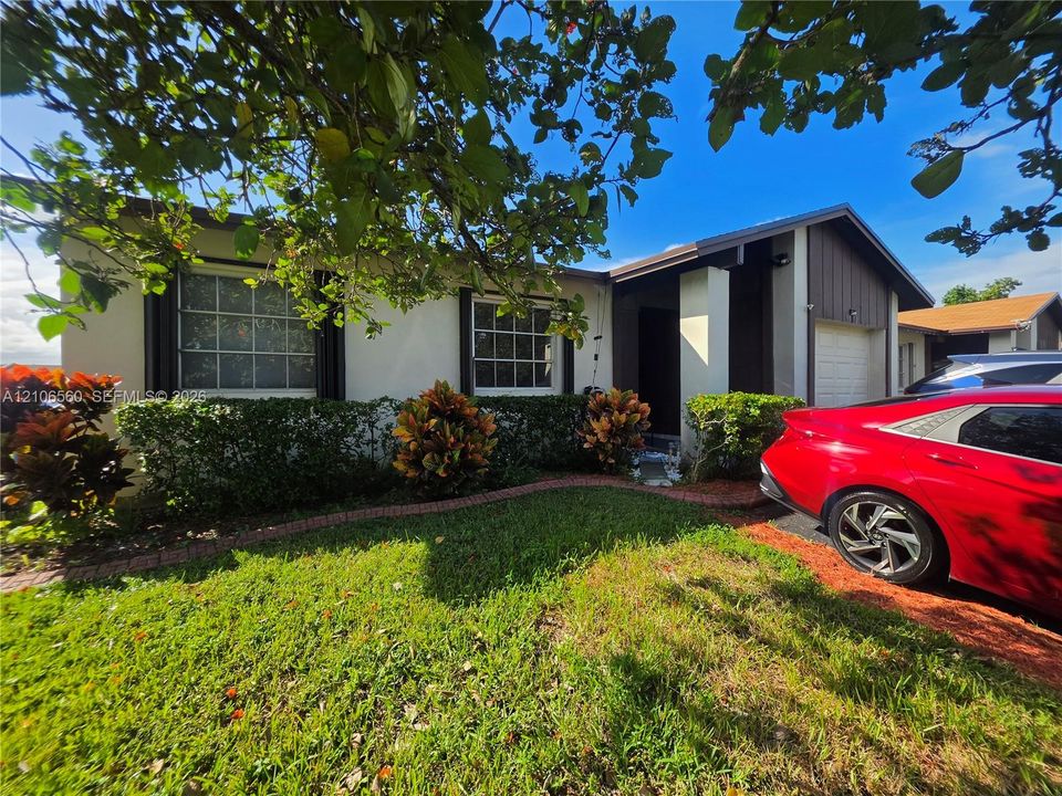Single-story residence featuring a stucco facade, divided-lite grid windows, covered entryway, and attached garage