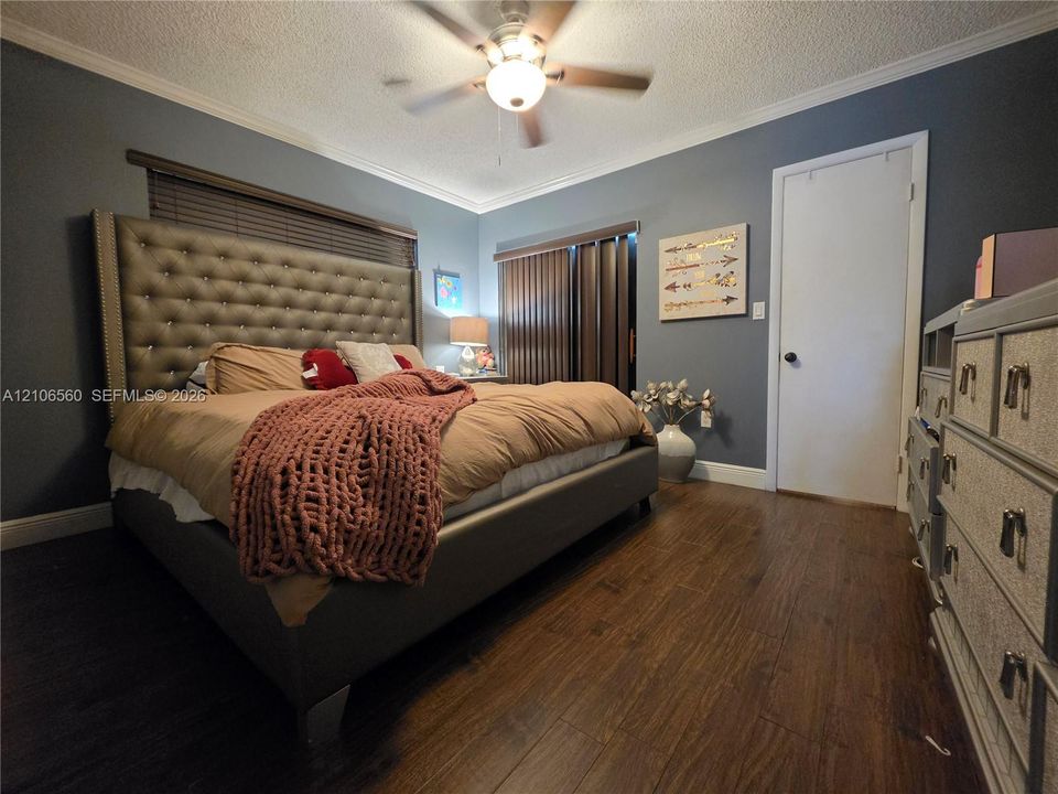 Wood-finish flooring, ceiling fan with integrated lighting, and vertical window blinds