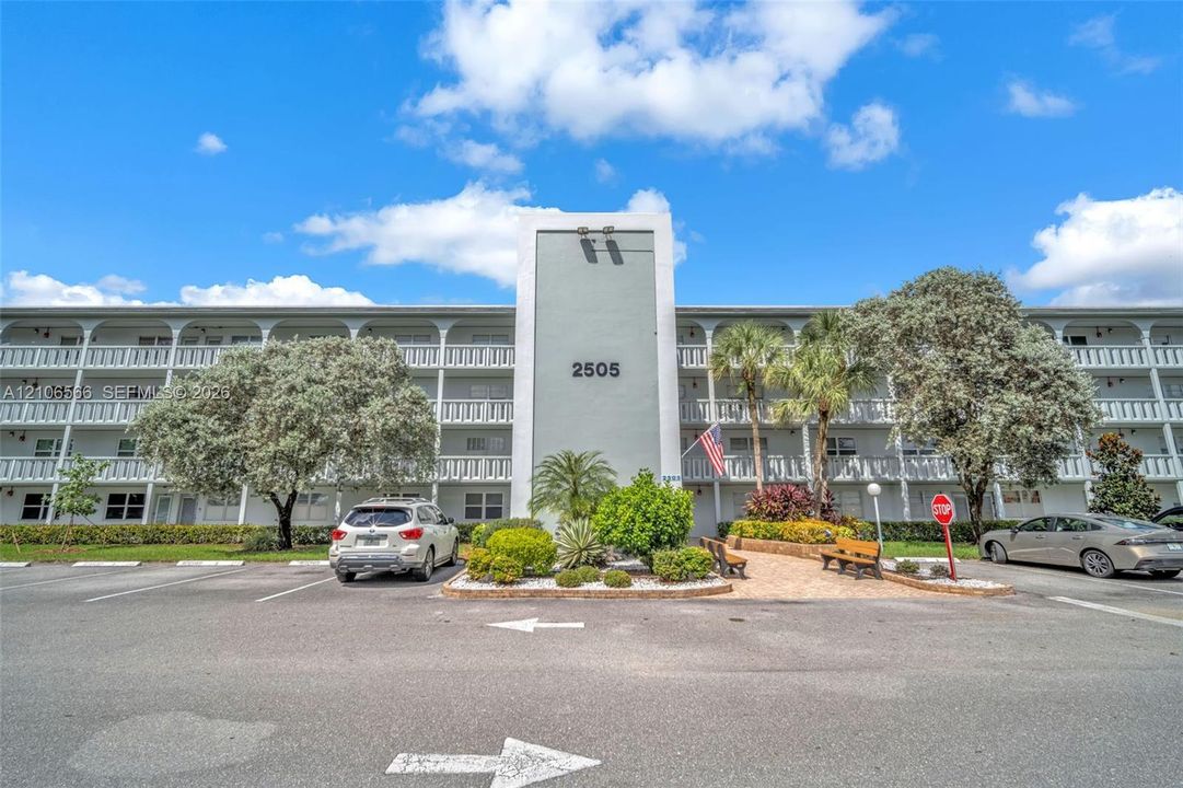 Mid-century modern multi-story residential exterior featuring arched architectural detailing, a central pillar facade, and surrounding mature landscaping