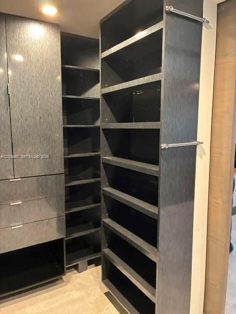 Custom dark-finish cabinetry featuring multi-level open shelving, integrated storage drawers, and polished chrome hardware accents