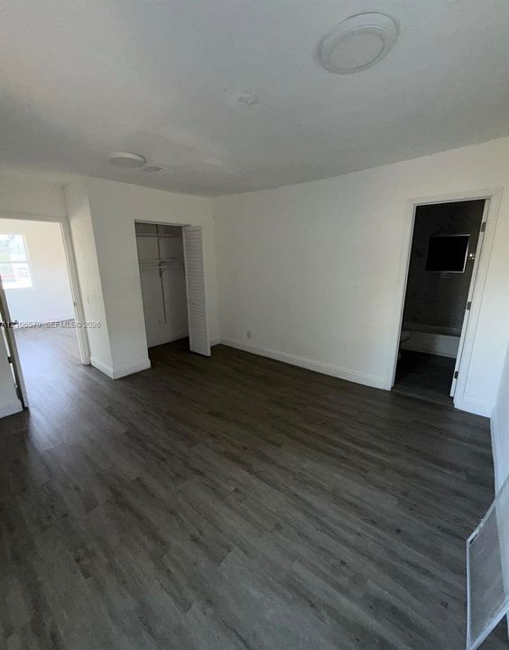 Interior space featuring wood-finish flooring, recessed lighting, and a closet with louvered doors