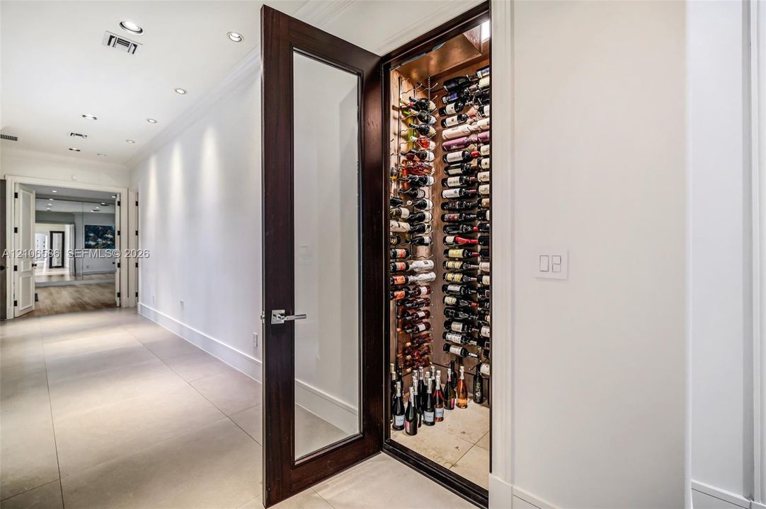 300-bottle, climate-controlled wine storage featuring a wood-finish door with glass inset, structured metal racking, and recessed interior lighting