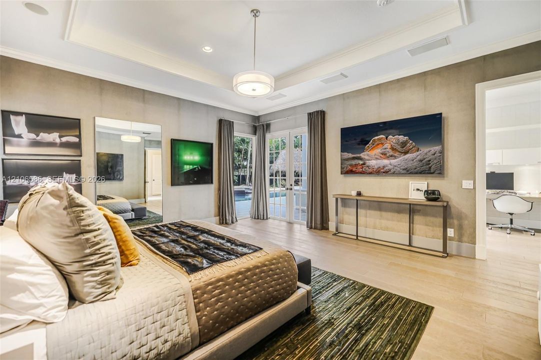 Tray ceiling with recessed lighting, wood-finish flooring, and glass-paned French doors