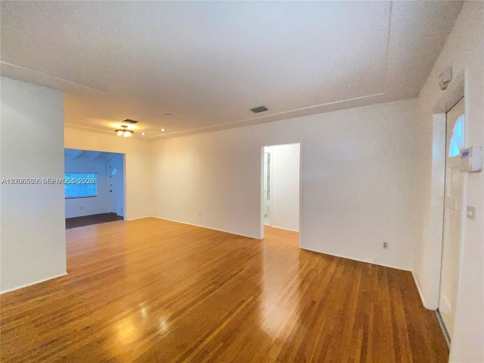 Interior space featuring wood-finish flooring, white walls, and a multi-light flush-mount ceiling fixture