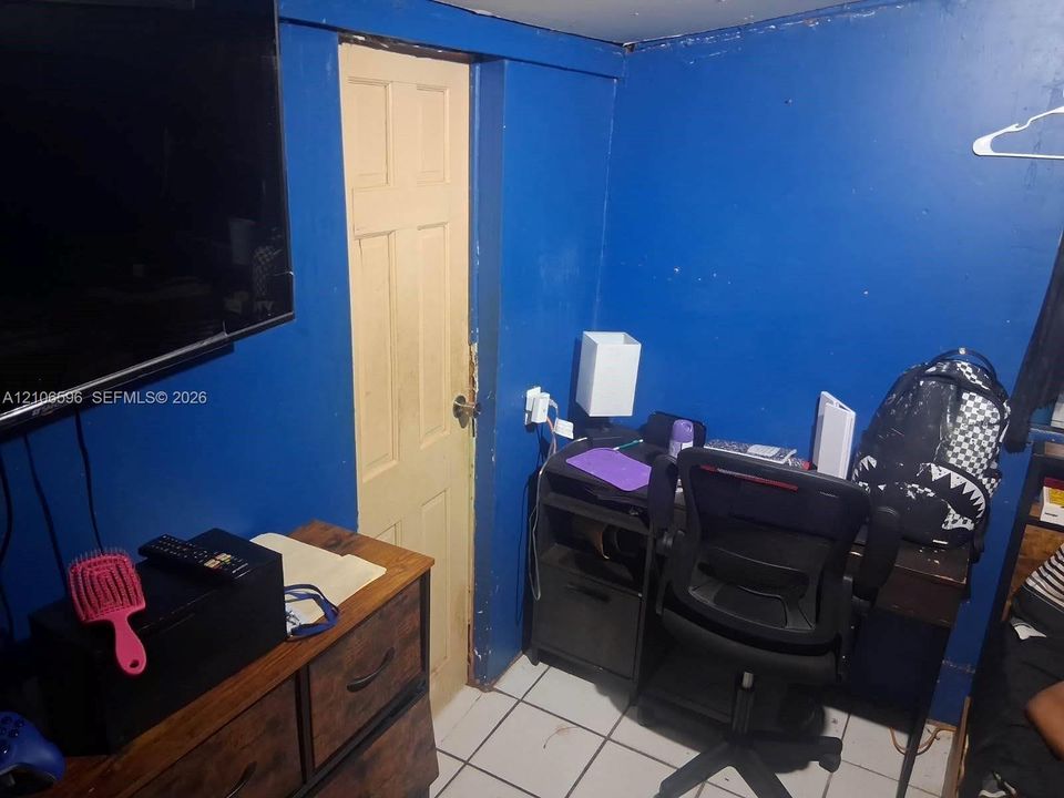 Interior room featuring white tile flooring and a six-panel door