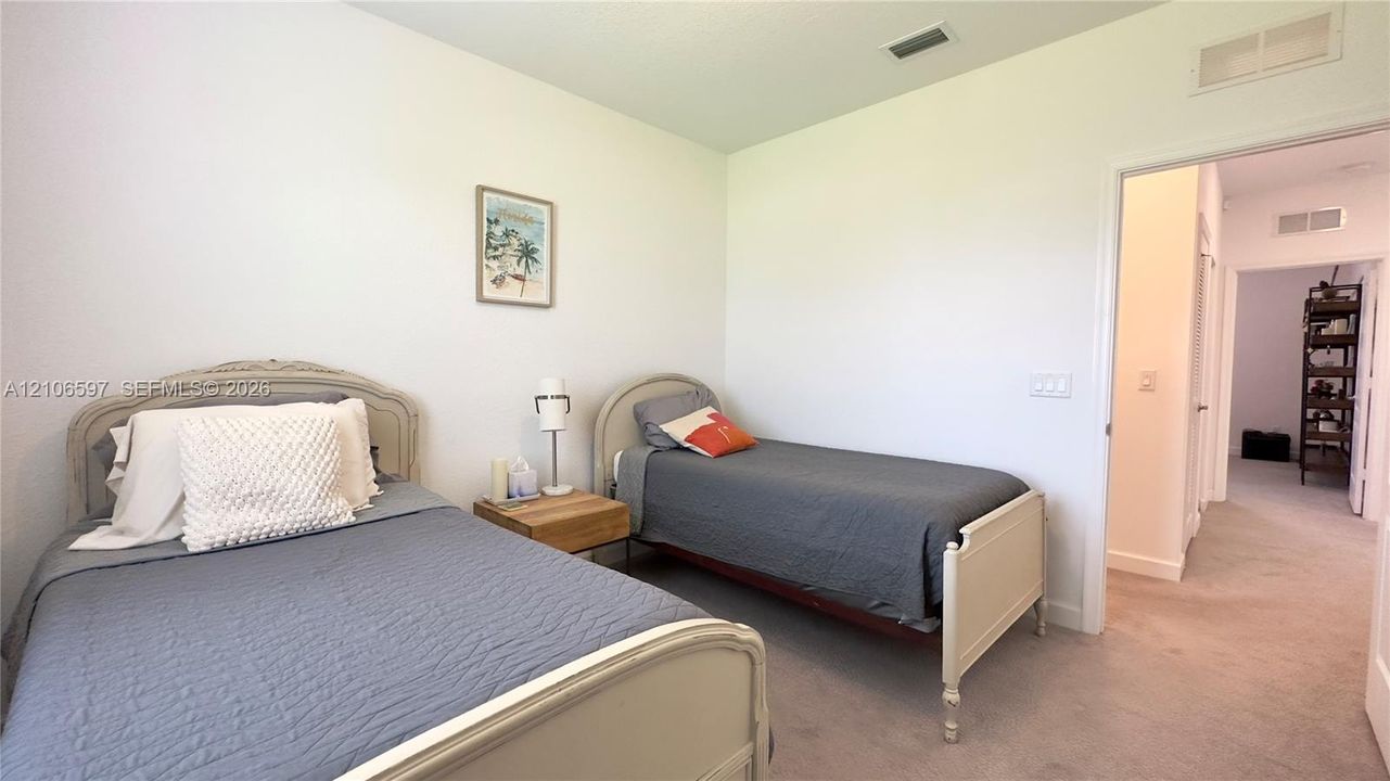 Neutral-toned interior space featuring light-colored wall paint and wall-to-wall carpeting