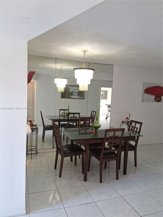 Large-format tile flooring, wall-to-wall mirrored accent, and multi-tier tiered pendant lighting