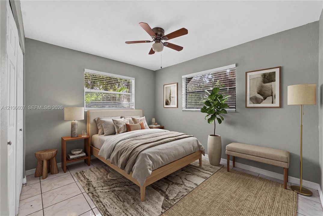 Bedroom featuring neutral wall paint, tile flooring, a ceiling fan with integrated lighting, and two windows with horizontal blinds
