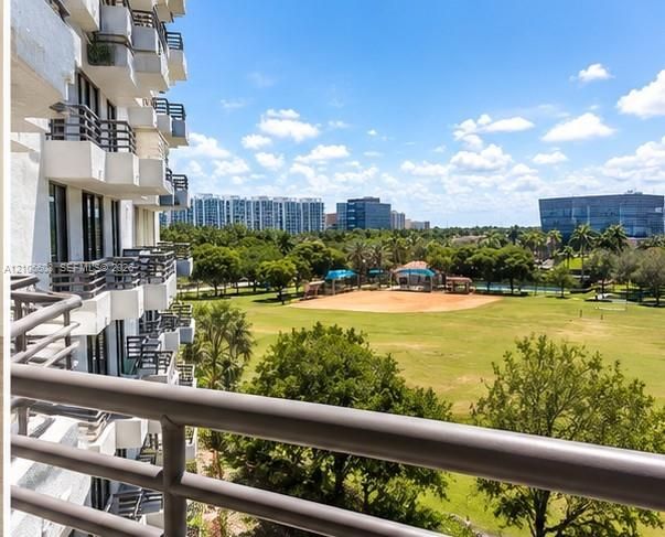 Elevated private balcony featuring metal railings and unobstructed exposure to the surrounding parkland, expansive green space, and mature trees