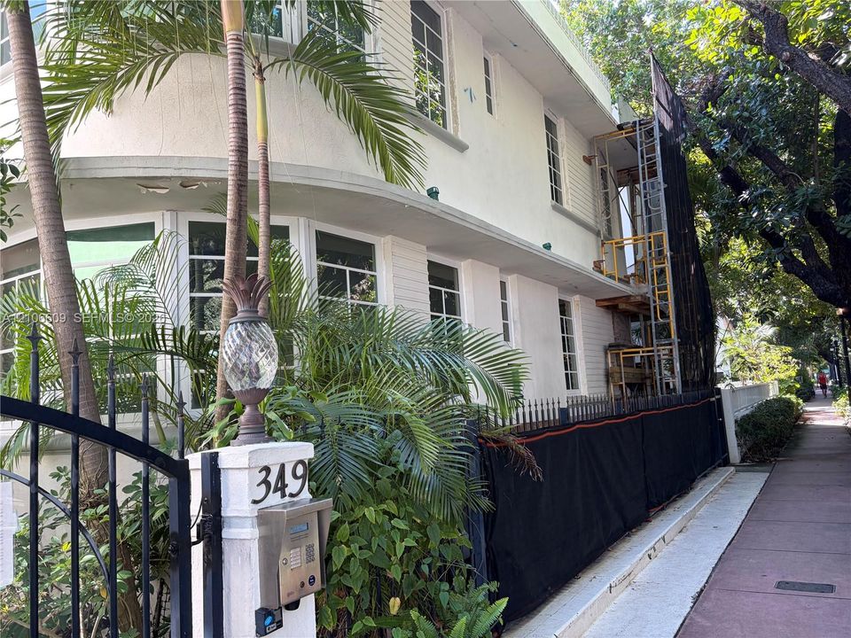 Art Deco exterior featuring curved architectural lines, multi-pane windows, smooth masonry facade, and an ornamental entrance pillar with integrated intercom system