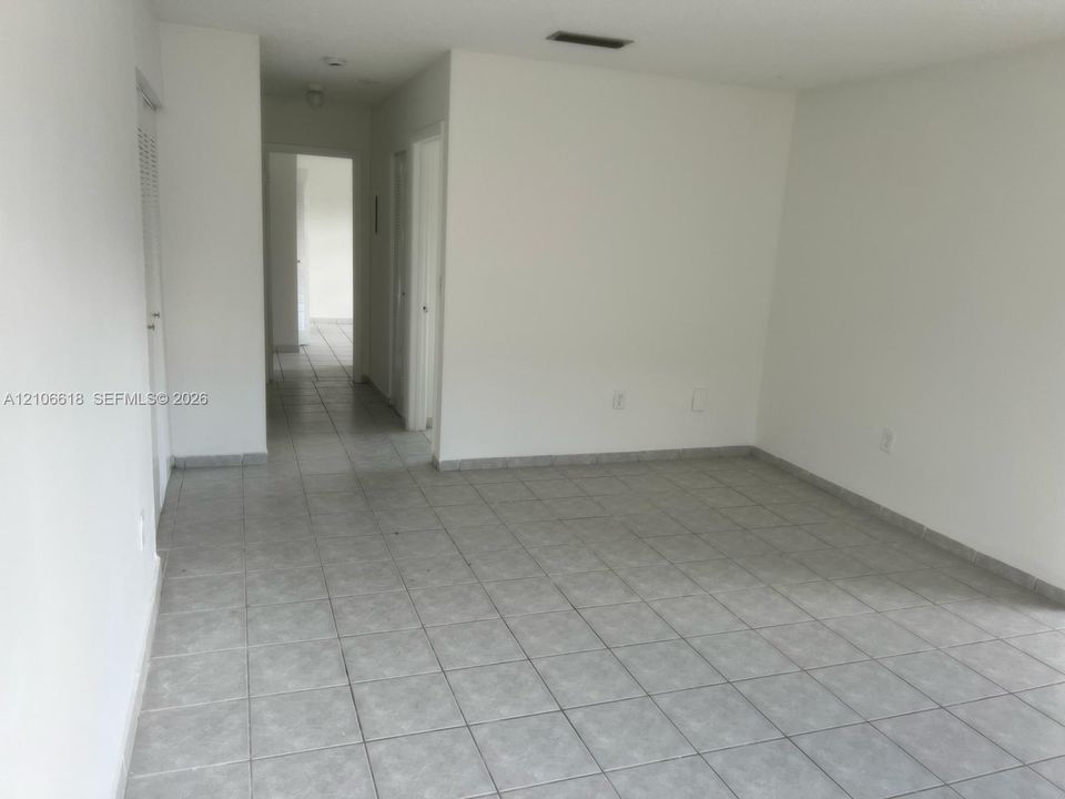 Neutral interior space featuring ceramic tile flooring, solid-wall construction, and multiple doorways