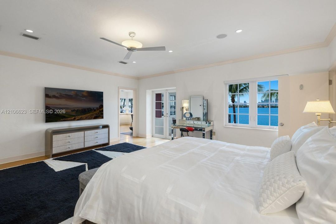 Spacious room featuring crown molding, recessed lighting, a modern ceiling fan, and multipane windows showcasing water