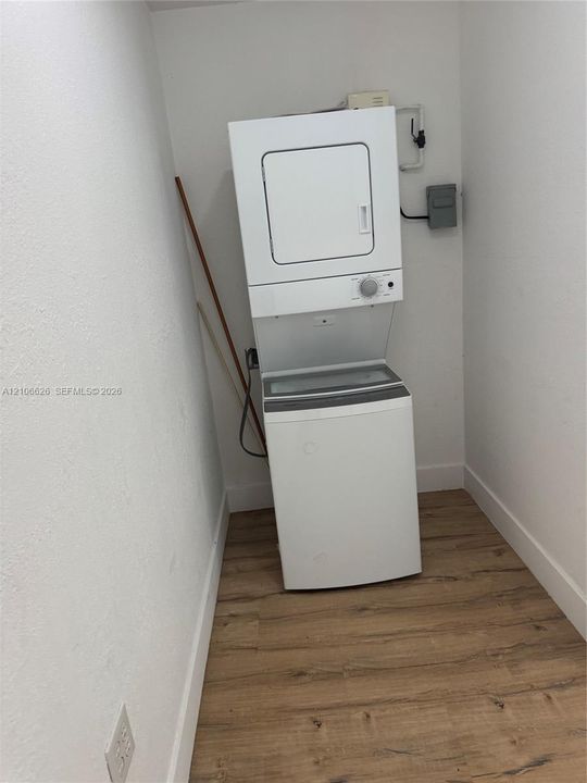Stacked laundry unit with wood-finish flooring