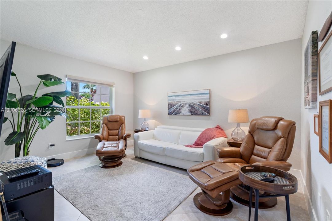 Neutral wall-toned room featuring recessed lighting, tile flooring, and a large multi-pane window
