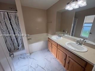 Dual-sink vanity with wood-finish cabinetry, solid surface countertop, large wall-mounted mirror, and tile flooring