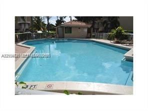 In-ground swimming pool with stone-style decking and a tiled surround
