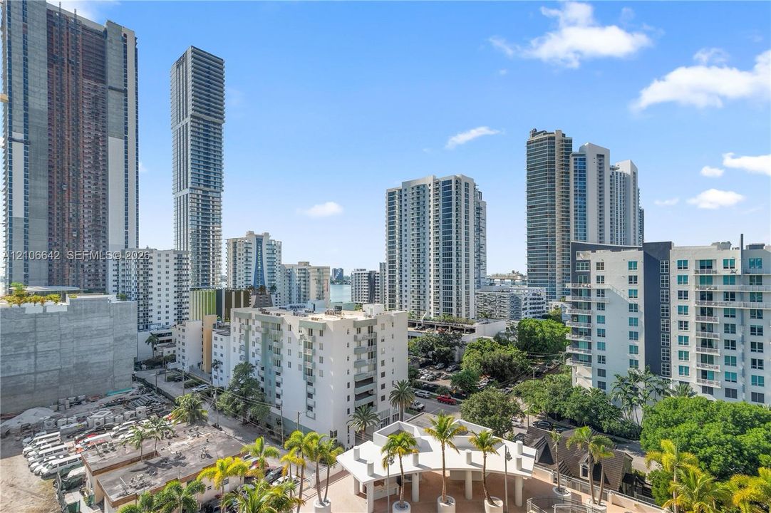 High-rise urban landscape featuring modern residential towers, mature palm trees, and structural balcony railings