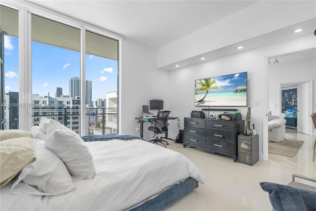 Floor-to-ceiling windows, polished tile flooring, recessed ceiling lighting, and a metal-railing balcony