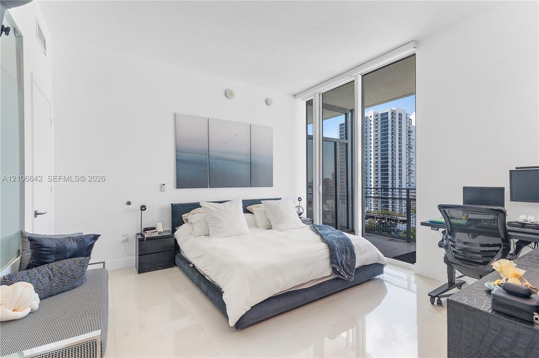 Floor-to-ceiling windows, polished tile flooring, and a private balcony access