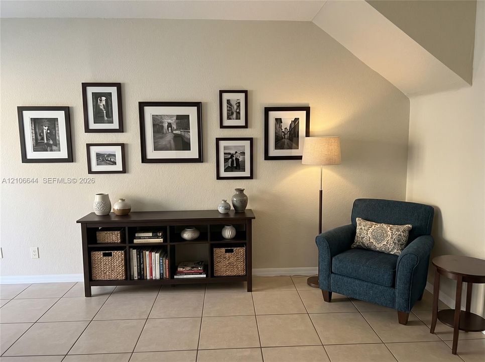 Neutral wall finish with an angled ceiling architectural detail and large-format tile flooring