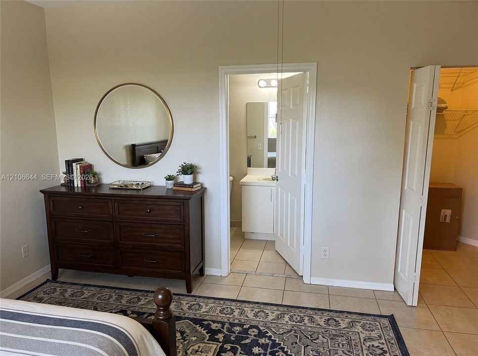 Room featuring tile flooring, six-panel interior doors, and a reach-in closet with built-in wire shelving