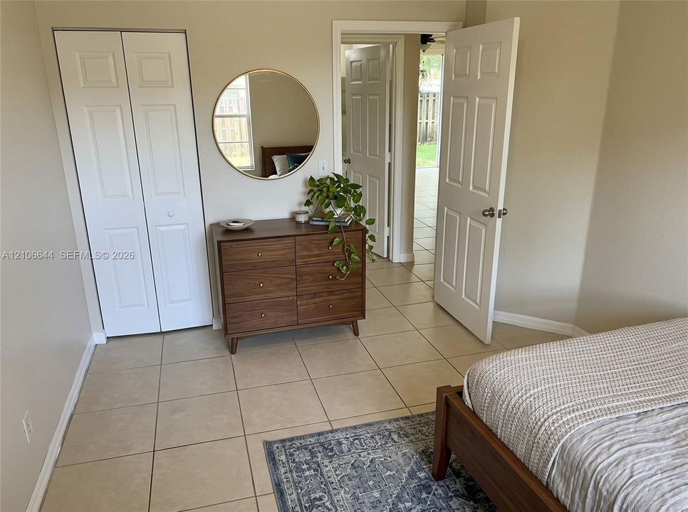 Neutral-tone interior featuring ceramic tile flooring, white six-panel interior doors, and bi-fold closet doors