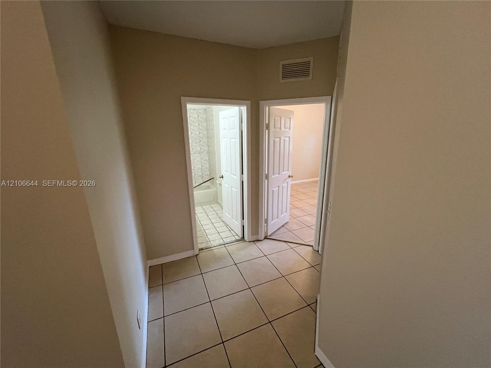 Ceramic tile flooring, white six-panel interior doors, and neutral-toned wall paint