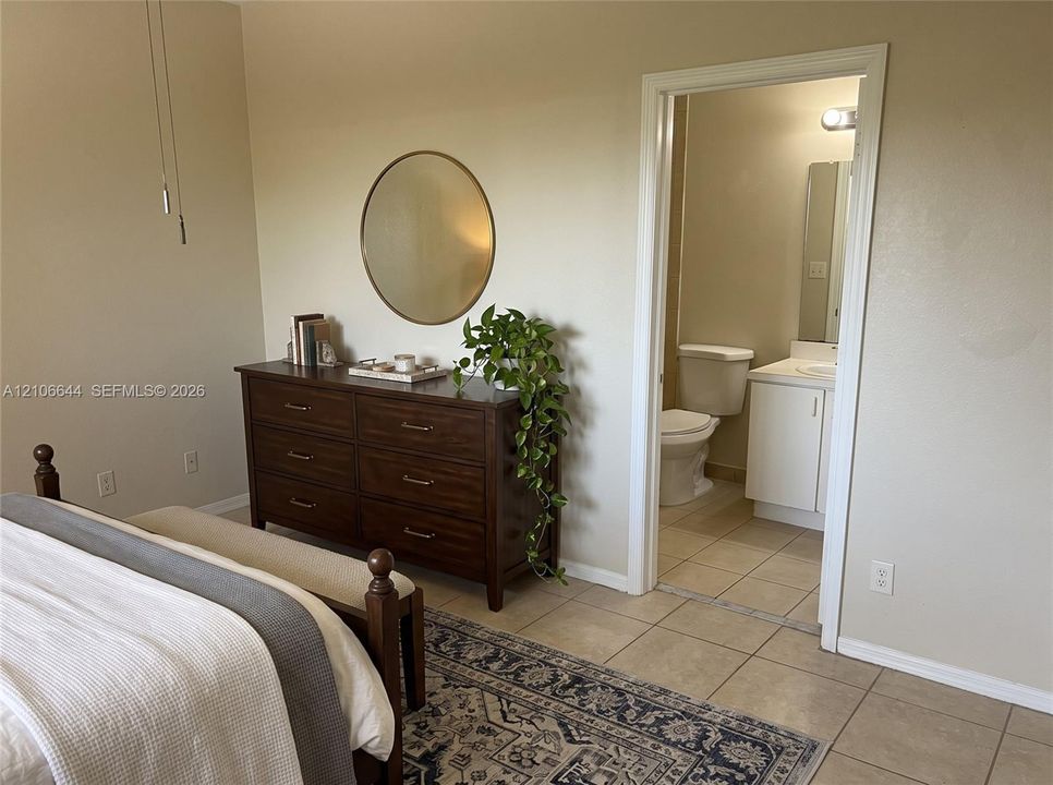 Neutral wall tones, ceramic tile flooring, and a vanity cabinet with a integrated sink