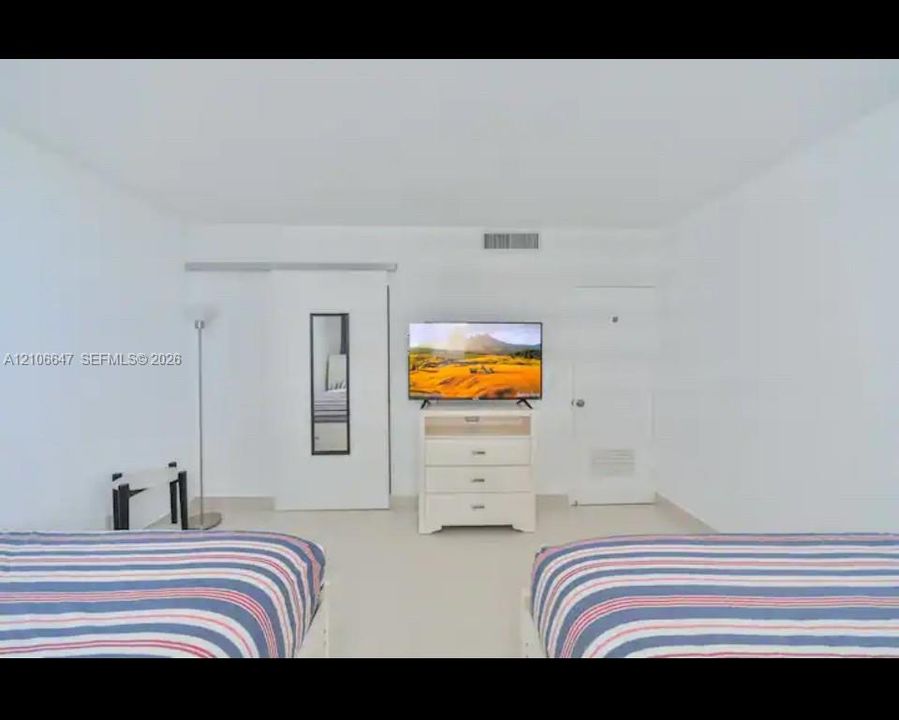 Room featuring neutral wall-to-wall flooring, a sliding door panel, and a solid-core interior door