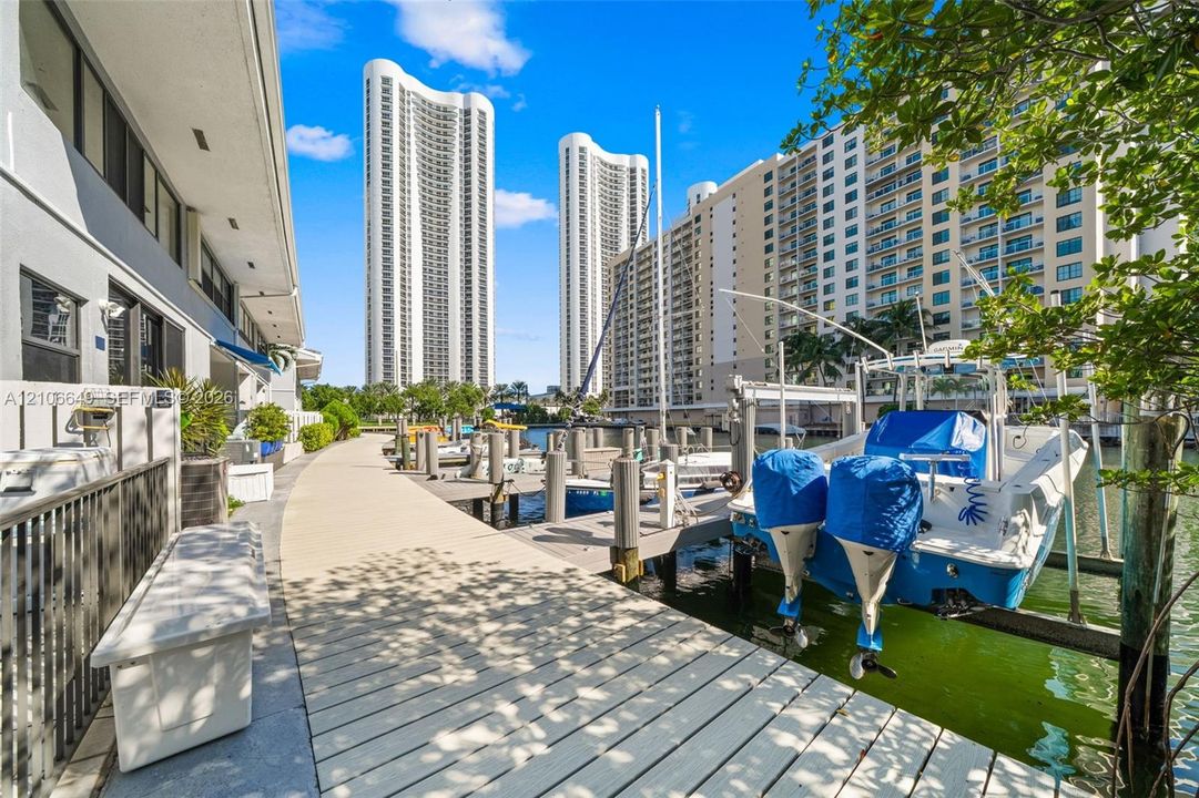 Waterfront boardwalk featuring a private boat slip, concrete bulkhead, and industrial-grade pilings