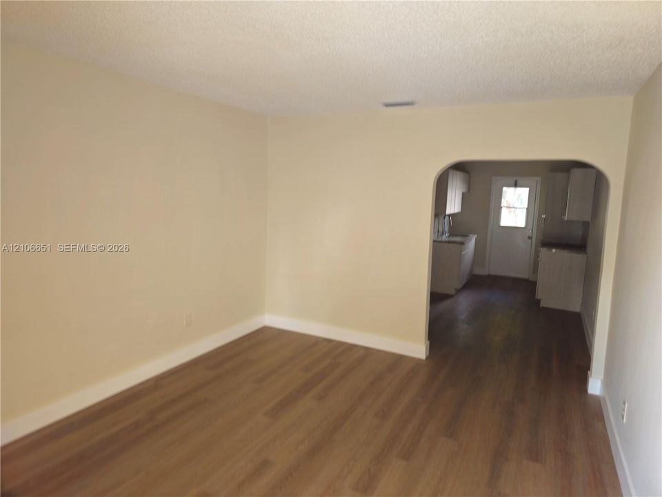 Interior space featuring wood-finish flooring and a rounded architectural archway
