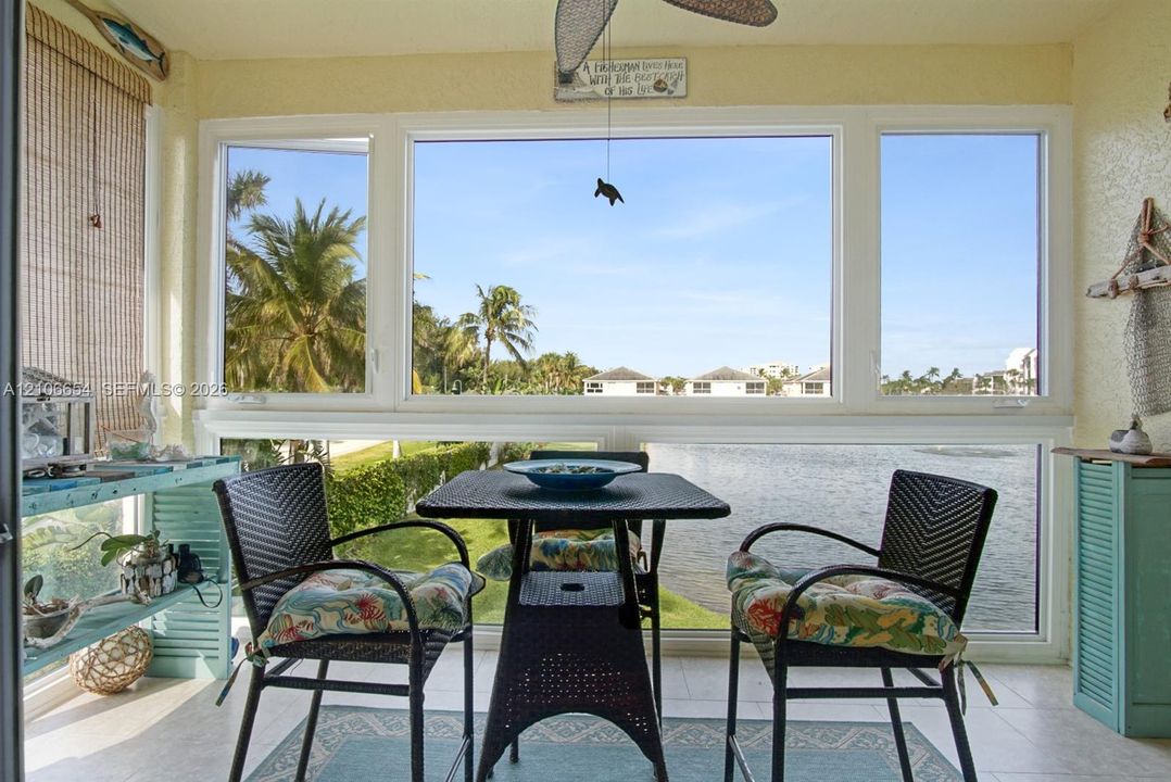 Enclosed sunroom featuring expansive multi-pane windows, ceramic tile flooring, and a ceiling fan