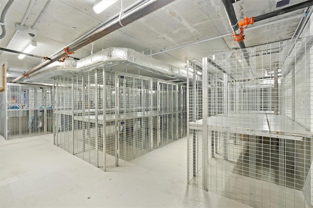 Secure, dedicated wire-mesh storage units with integrated elevated shelving and concrete flooring