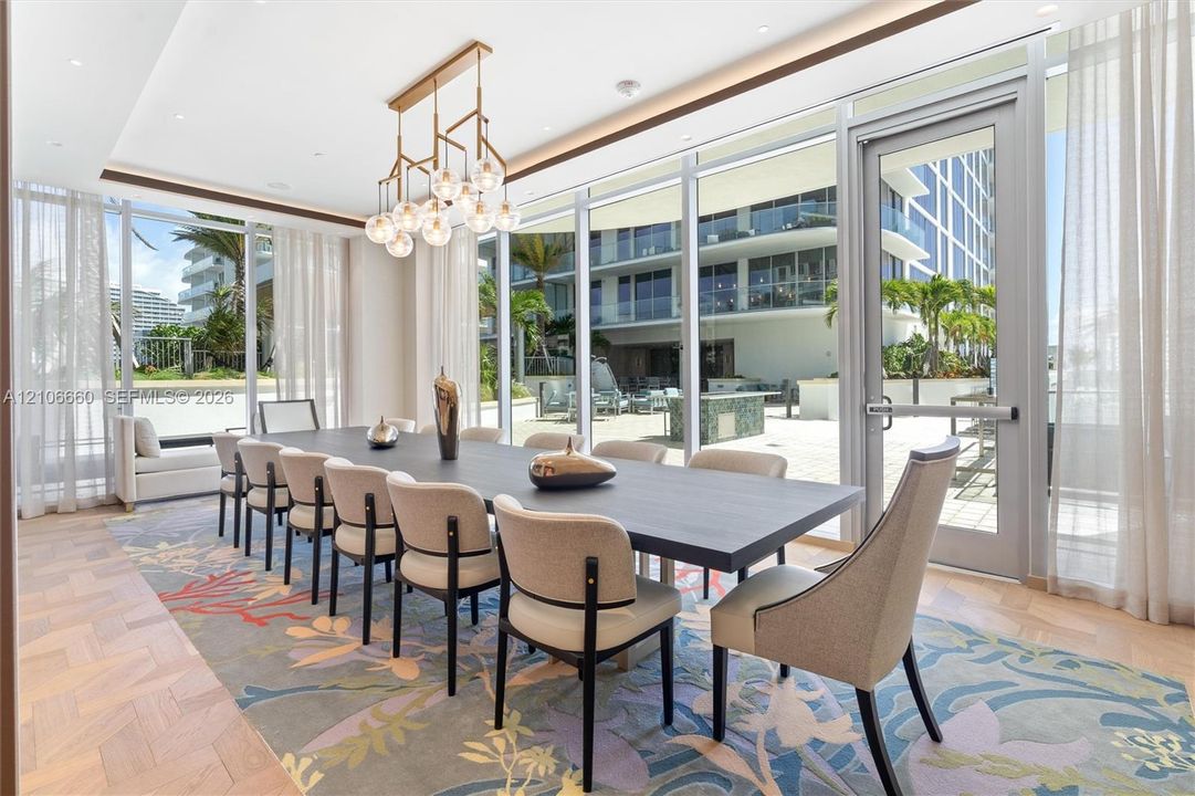 Floor-to-ceiling glass walls, herringbone-patterned wood-finish flooring, multi-light geometric chandelier, and recessed ceiling lighting