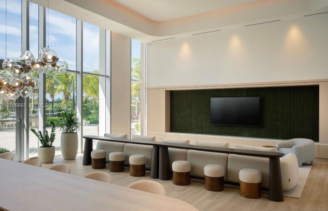 Floor-to-ceiling glass windows, recessed ceiling lighting, wood-finish flooring, integrated wall-paneling, and multi-light spherical chandelier