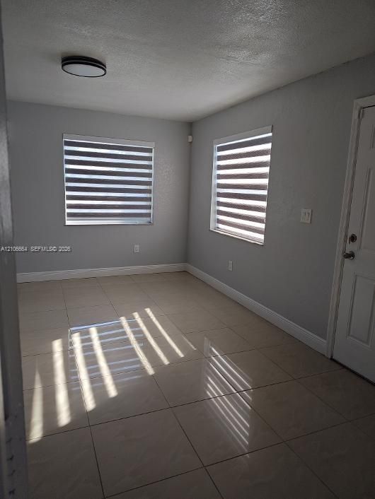 Neutral-toned tile flooring, dual-pane windows with integrated adjustable light-filtering shades, and flush-mount ceiling lighting