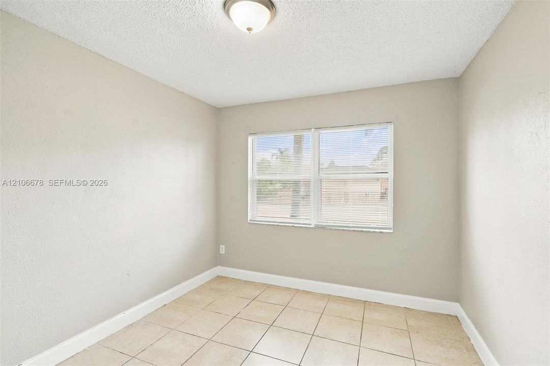 Interior room featuring neutral-toned walls, tile flooring, and a flush-mount ceiling light fixture
