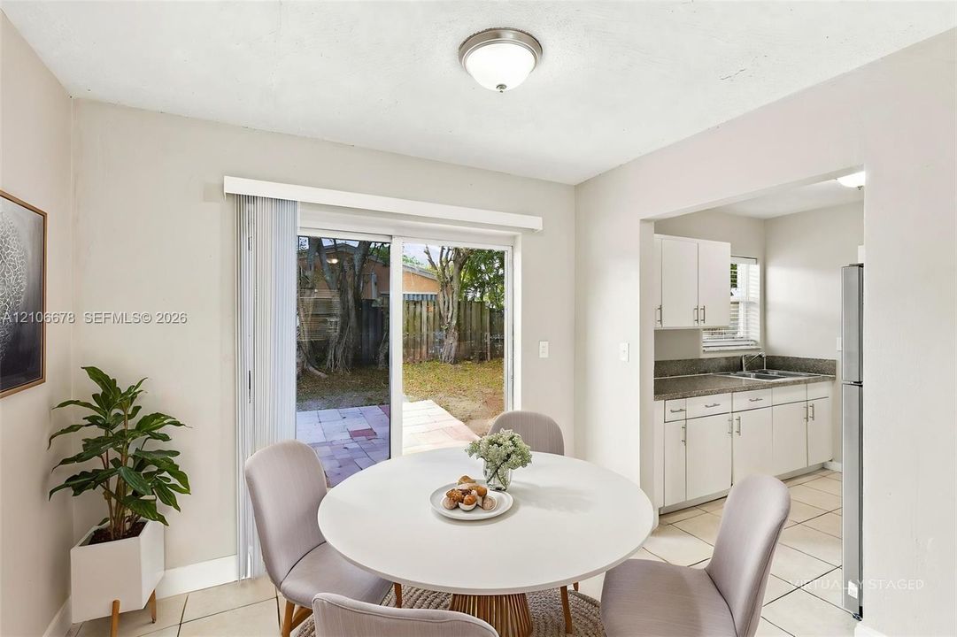 Sliding glass door, tiled flooring, white cabinetry, stone-finish countertops, and flush-mount ceiling lighting