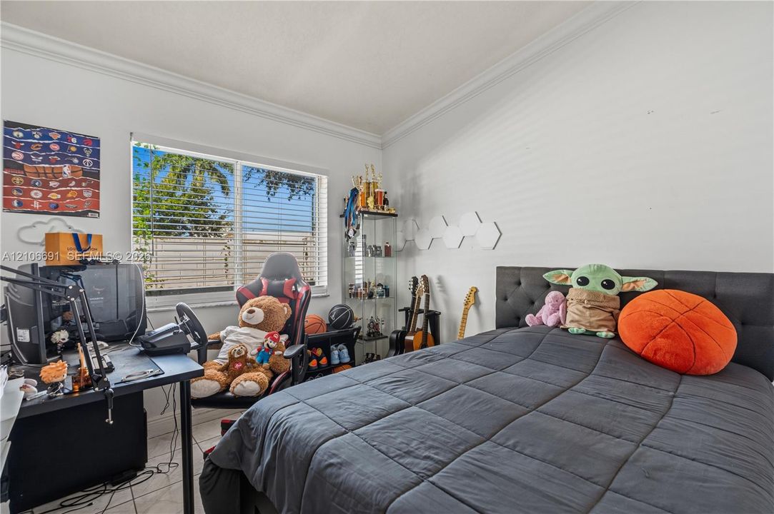 Room interior featuring tile flooring, crown molding, and a horizontal window with horizontal blinds