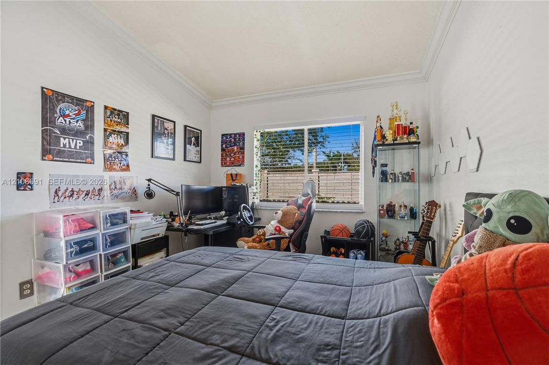 Room featuring crown molding, neutral wall color, and a window with horizontal blinds