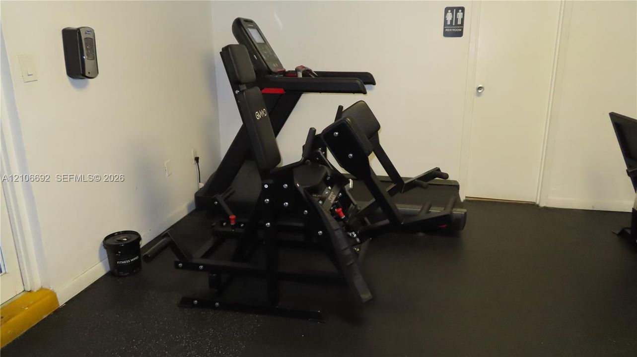 Fitness center featuring black resilient rubber flooring and interior doorway access