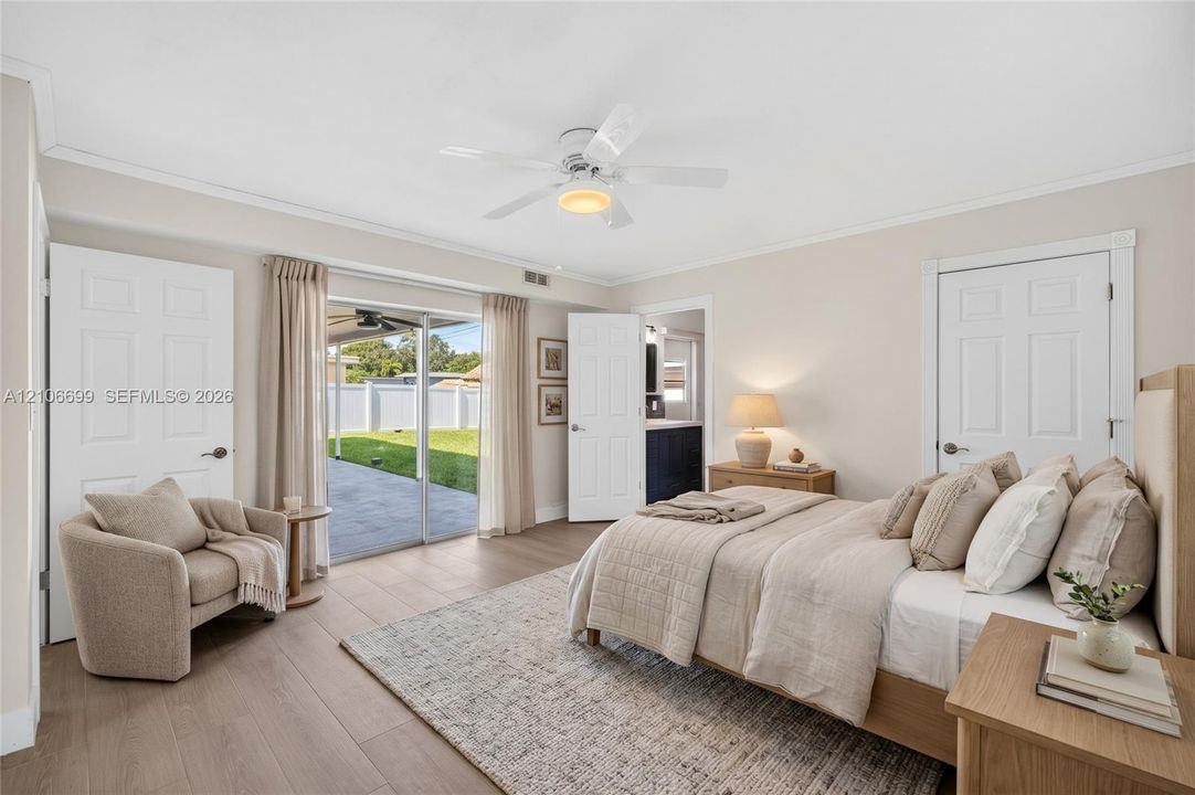 Primary bedroom w/ walk in closet w/ built-ins, en suite bathroom leading to backyard w/ new plank wood look tile