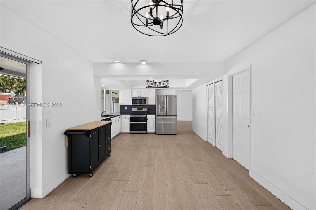Open concept kitchen w/ updated plank wood look tile, stainless appliances approx 2020