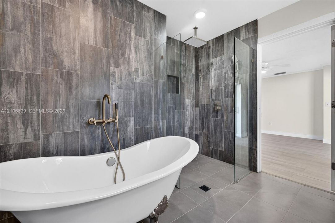 Primary bathroom w/ door to backyard. Separate tub & shower