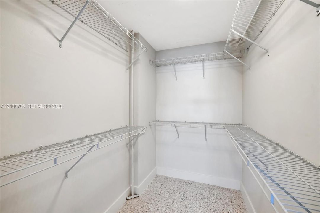 Storage area featuring multi-level white wire shelving and neutral flooring
