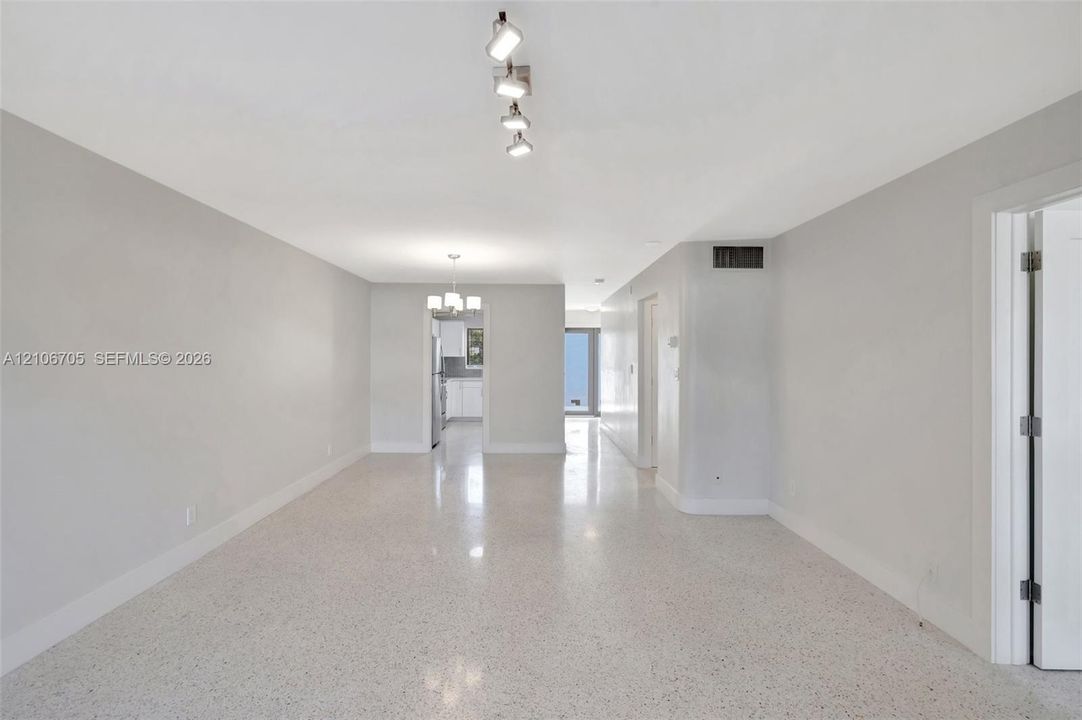 Open-concept interior featuring light-toned interior paint, polished terrazzo flooring, and a multi-directional track lighting fixture