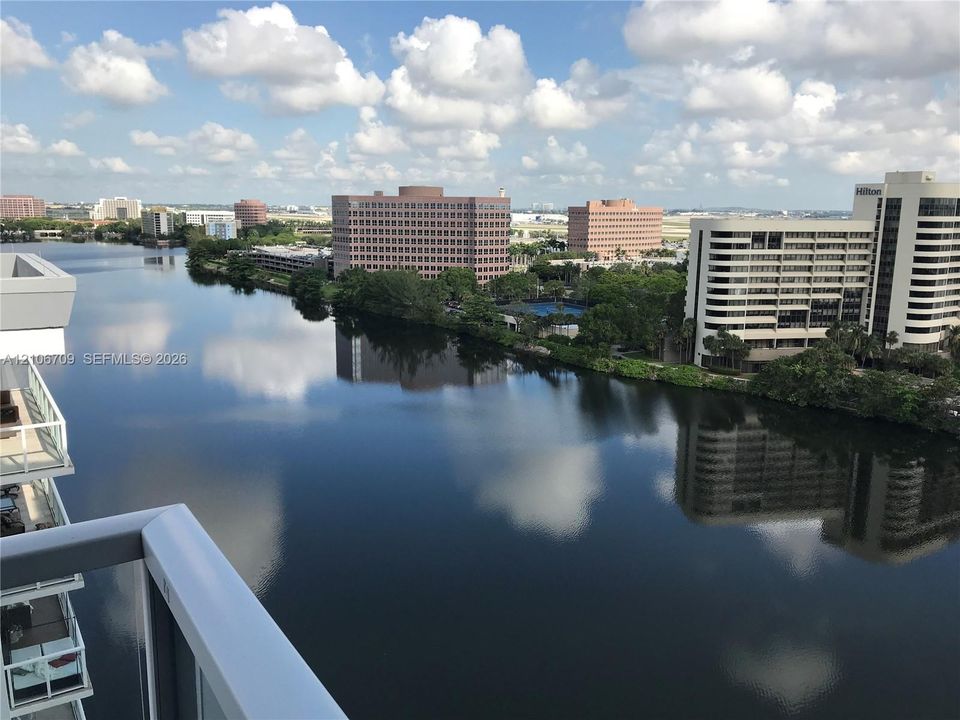 High-rise balcony featuring a glass panel railing and panoramic water-front perspective