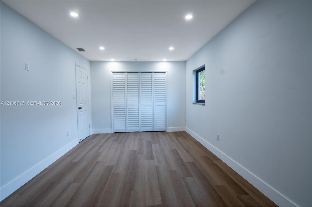 Interior space featuring wood-finish flooring, recessed lighting, and white louvered closet doors